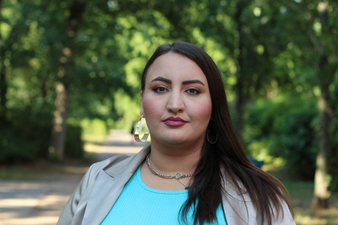 Portraitaufnahme von Aktivistin Roxanna-Lorraine Witt stehe vor Bäumen