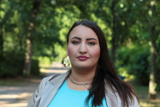 Portraitaufnahme von Aktivistin Roxanna-Lorraine Witt stehe vor Bäumen