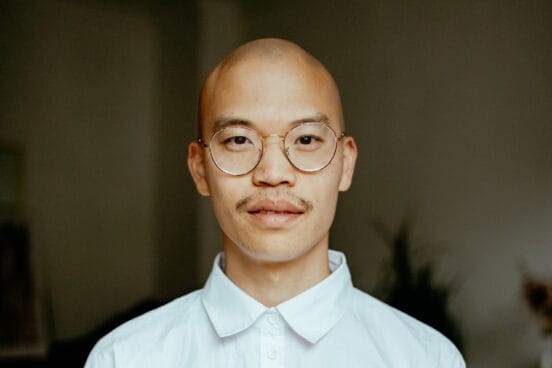 Regisseur Dieu Hao Do schaut in die Kamera und trägt eine weißes Hemd